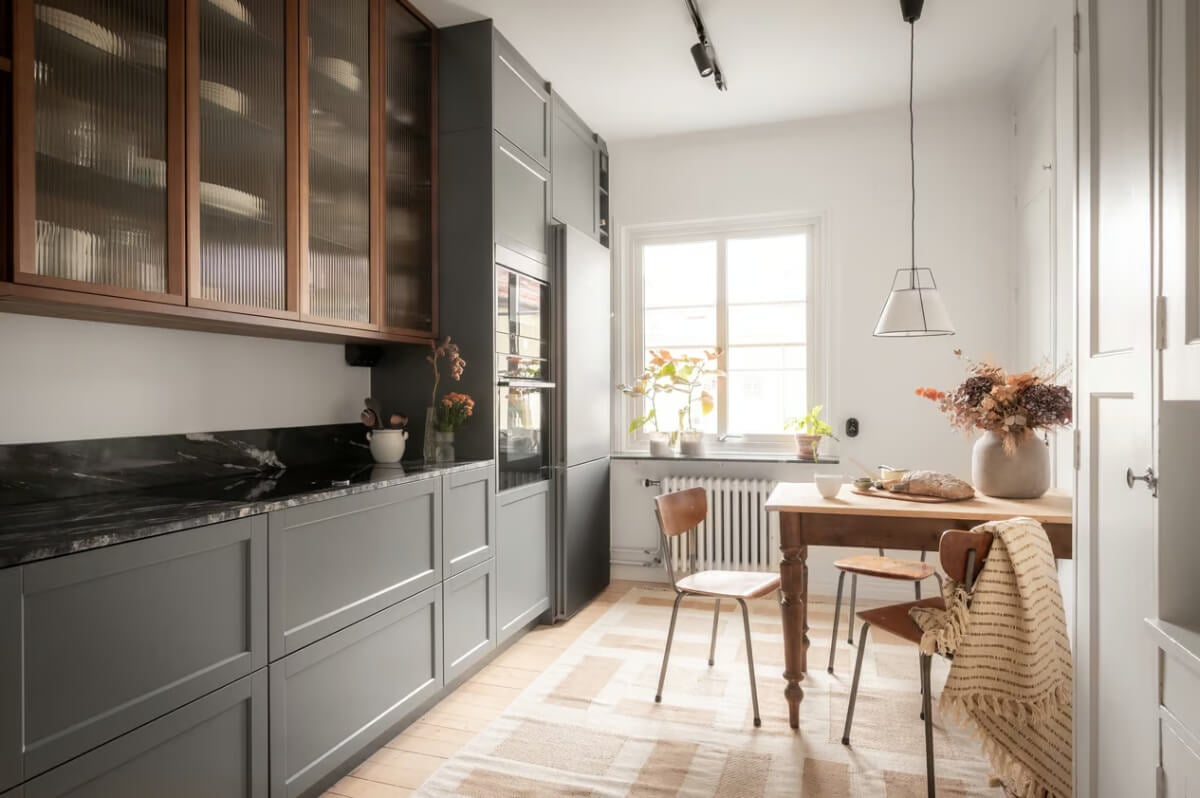 A Swedish Attic Apartment with Exposed Brick and Yellow Color Accents 6 gray kitchen with vintage wooden table