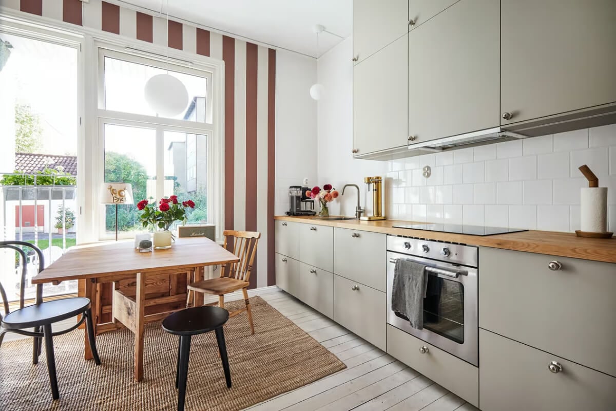 A Bright Turn-of-the-Century Apartment in Sweden 7 gray kitchen wooden worktop striped wallpaper