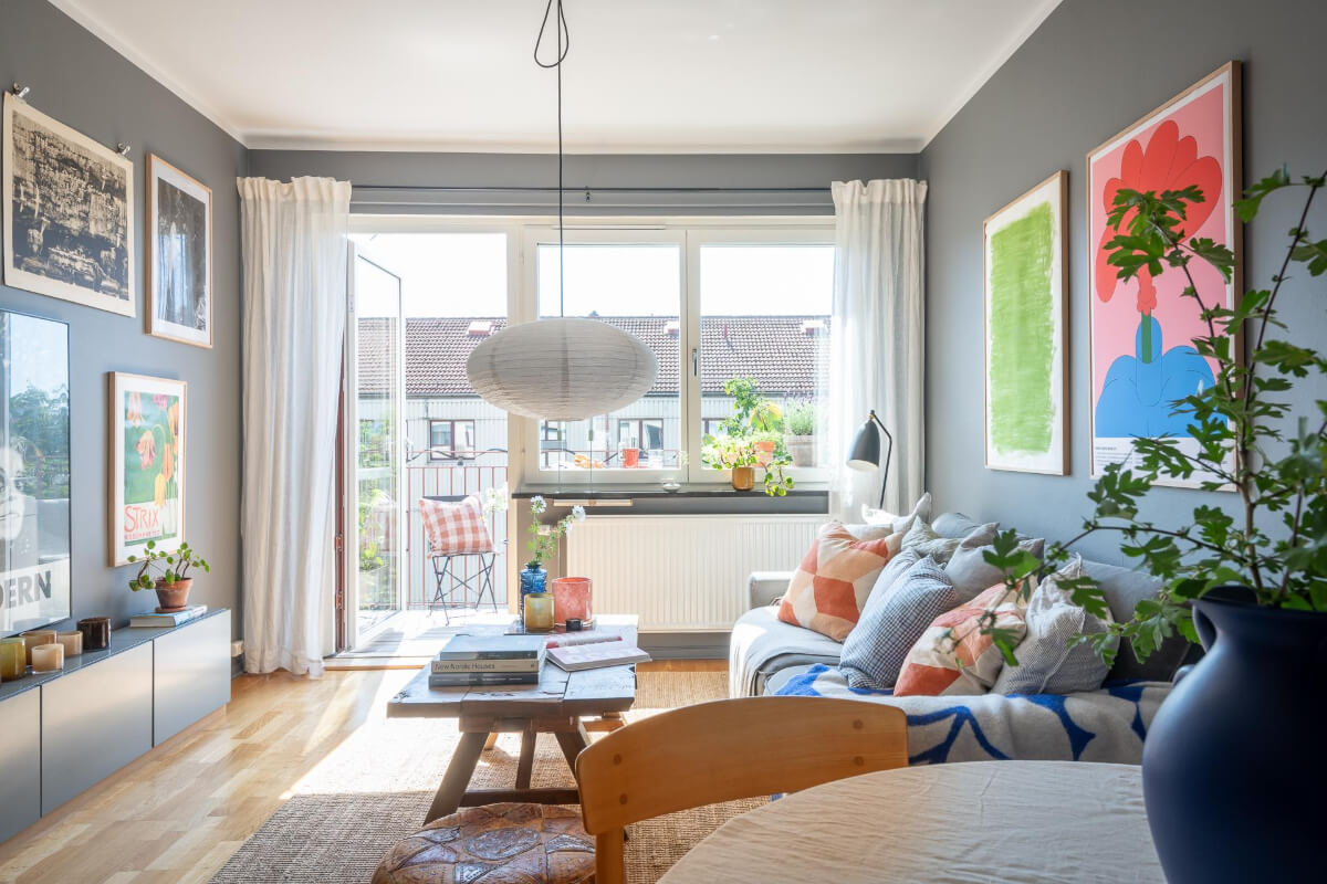 Light Rooms and a Moody Color Palette in a 1930s Apartment 6 gray living room large window colorful art