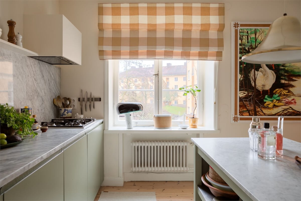 A Light-Filled Two Bedroom Apartment in Stockholm 7 green kitchen cabinets marble countertop and backsplash