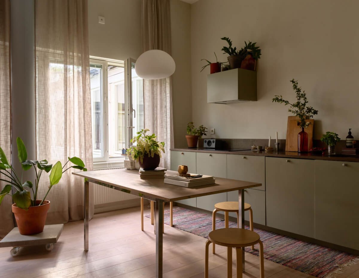 High Ceilings in a Small Swedish Loft Designed for a Family 3 green kitchen with dining table