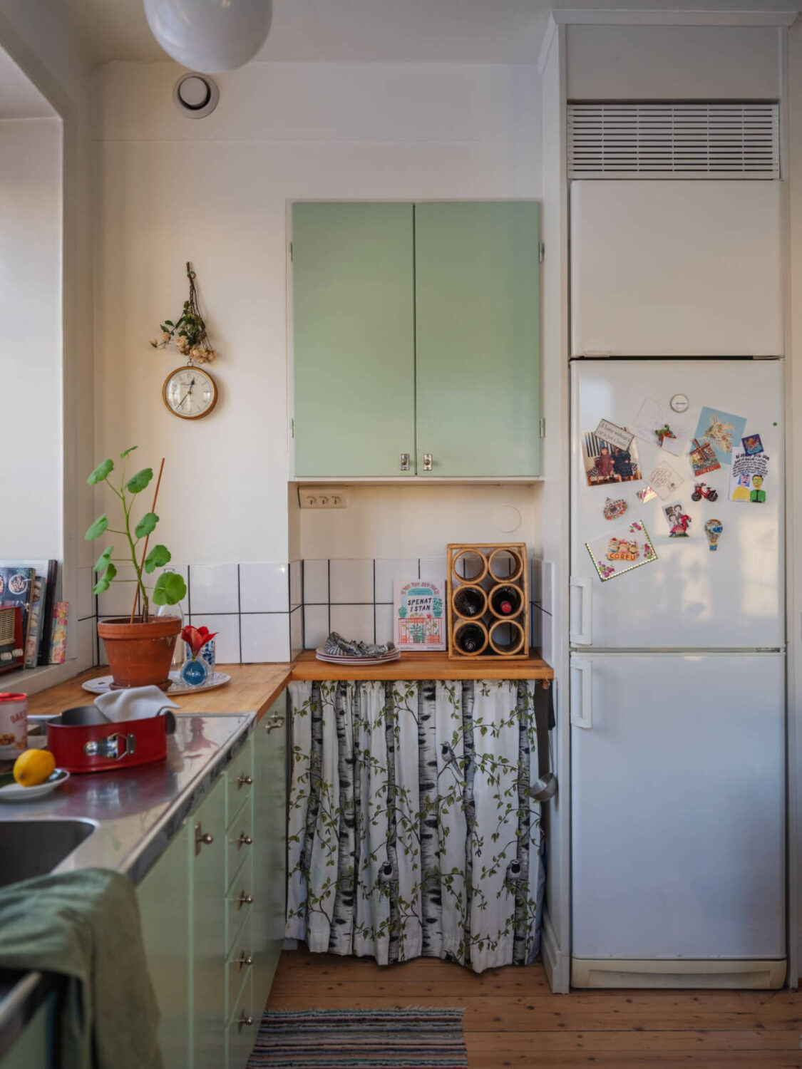 A Charming and Light-Filled Studio Apartment in Stockholm 14 green midcentury kitchen with wooden floor