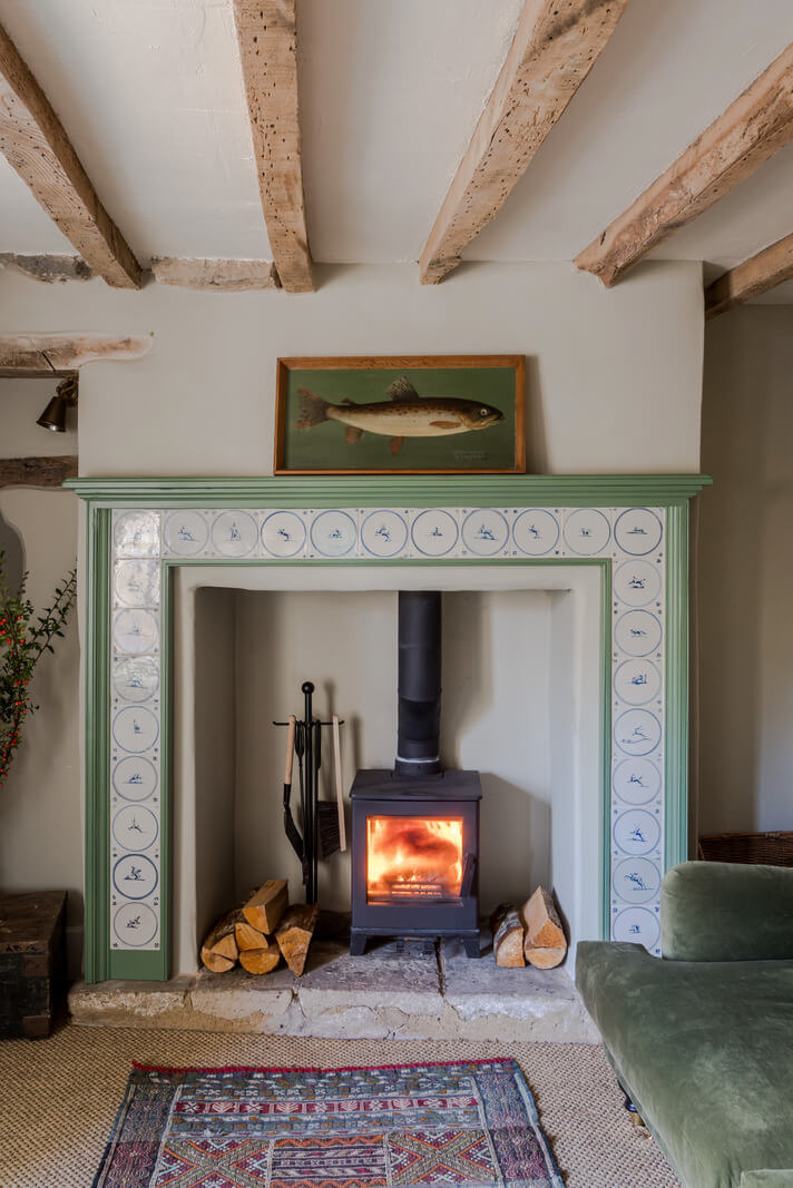 A Carefully Selected Color Palette in an 18th-Century English Cottage 3 green tiled fireplace mantel with wood burner