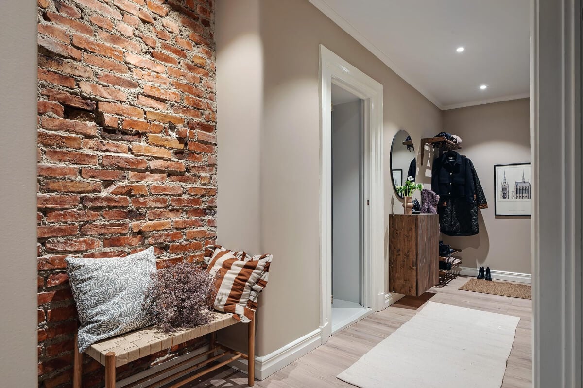 Warm and Inviting Rooms in a Renovated Swedish Apartment 30 hall-exposed-brick-wall.jpg