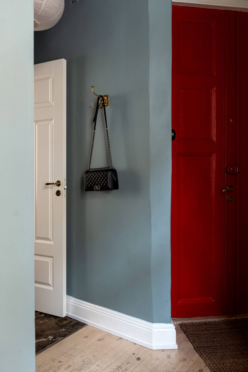 An Elegant Stockholm Apartment with a Pink and Black Kitchen 24 hall red front door