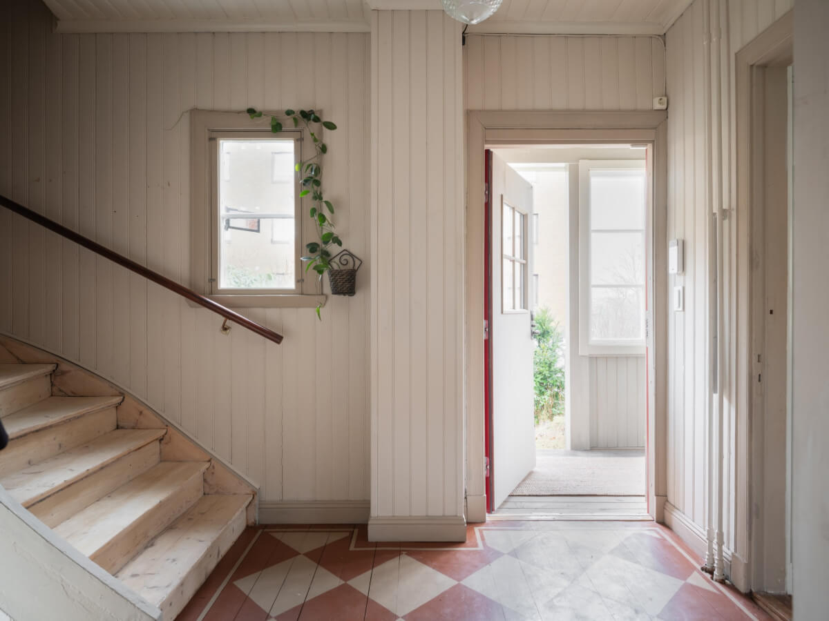 A Carefully Renovated Family Home in Sweden 25 hall with painted wooden floorboards in checkerboard pattern