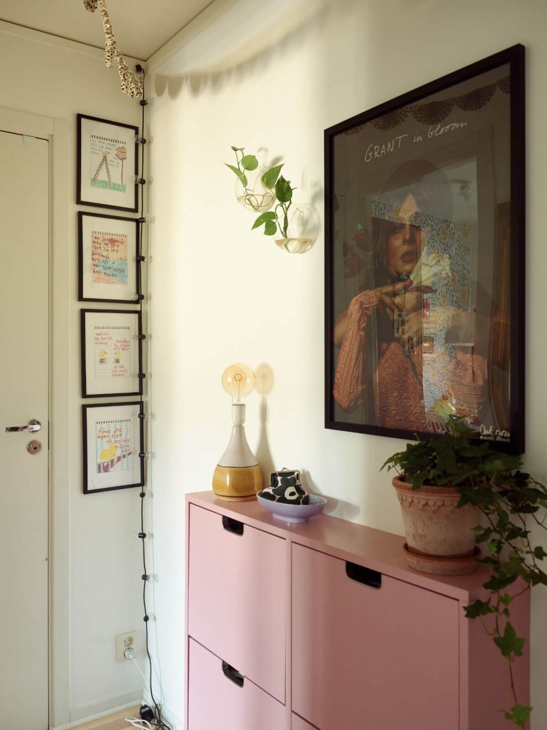 A Colorful Midcentury Apartment Filled with Art and Plants 21 hallway pink shoe cabinets