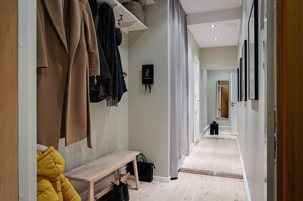 A Swedish Apartment with an Open Living Space and Period Features 29 hallway storage behind curtain