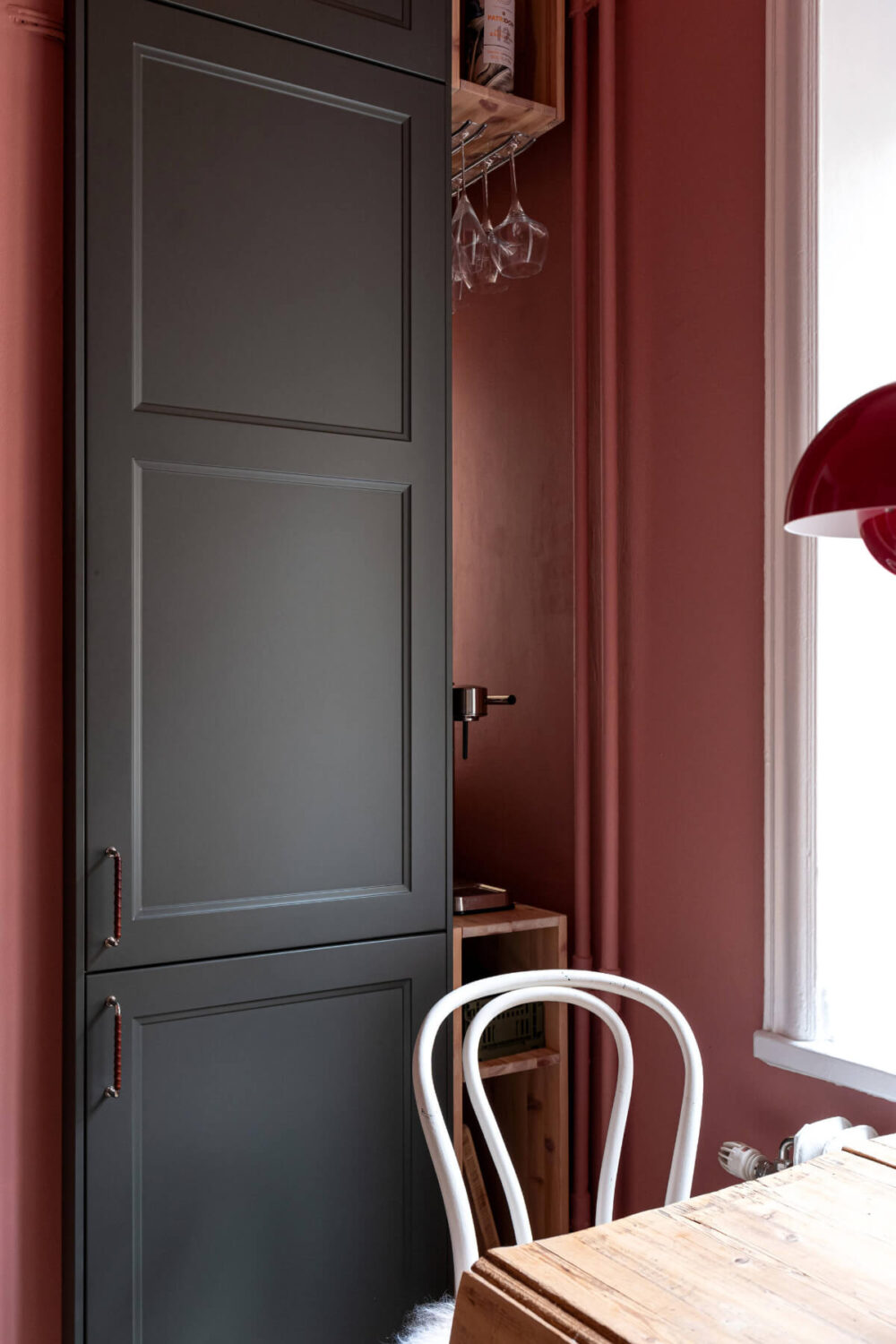 An Elegant Stockholm Apartment with a Pink and Black Kitchen 14 kitchen detail pink walls black cabinet doors