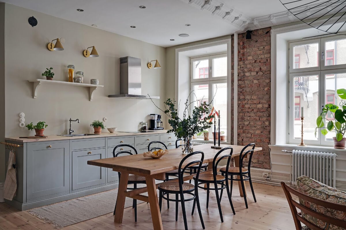A Swedish Apartment with an Open Living Space and Period Features 13 kitchen exposed brick wall dining table