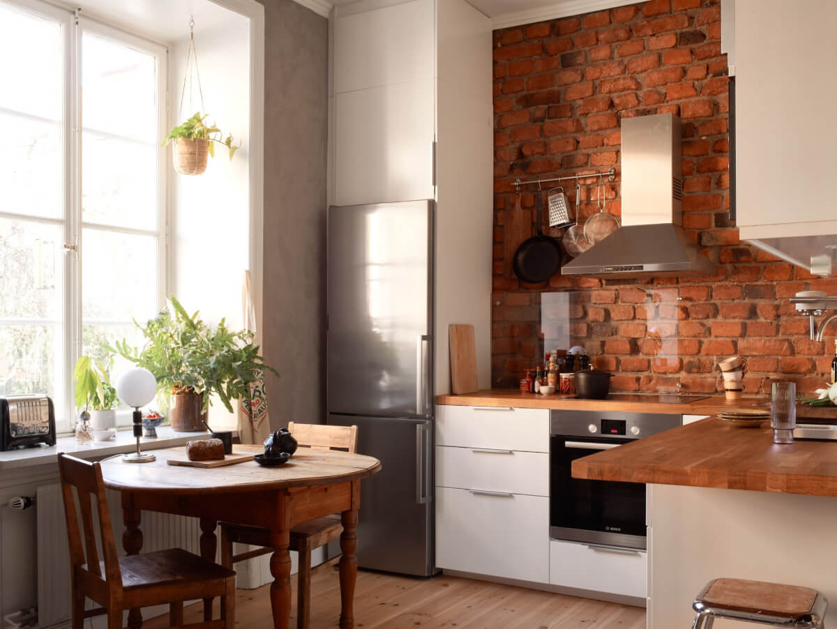 A Studio Apartment with Smart Storage Ideas and Exposed Brick 7 kitchen exposed brick wall vintage wooden table