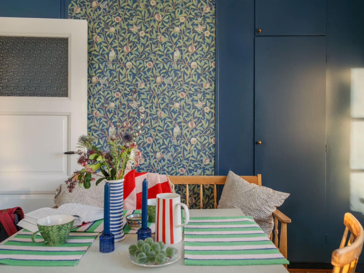 A Charming and Light-Filled Studio Apartment in Stockholm 15 kitchen table and blue wallpaper
