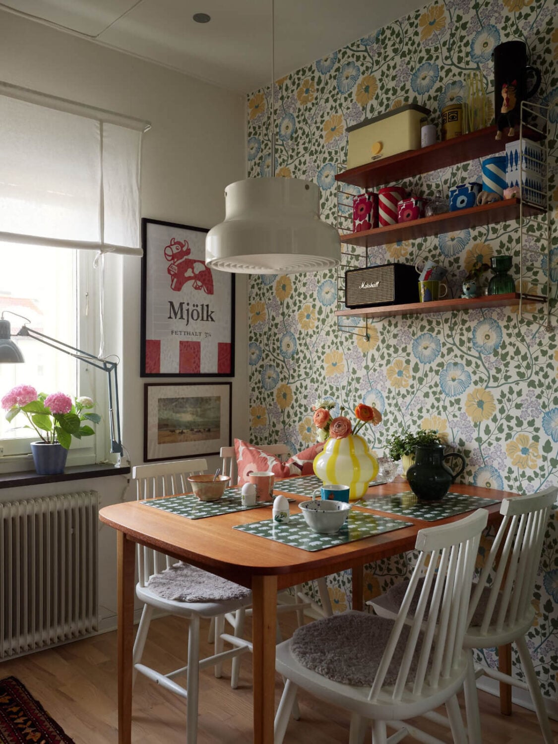 A Colorful Midcentury Apartment Filled with Art and Plants 13 kitchen table floral wallpaper shelves