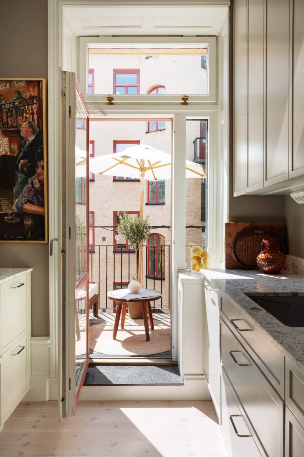 A Calm, Neutral Color Palette in a Classic Swedish Apartment 13 kitchen view to balcony