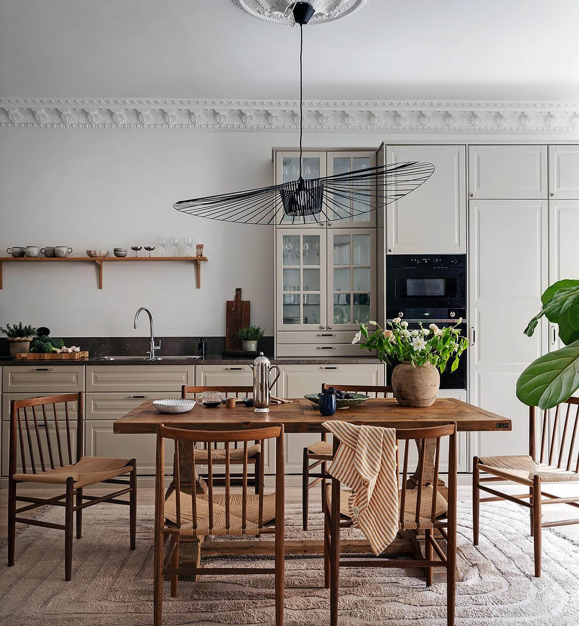 Warm and Inviting Rooms in a Renovated Swedish Apartment 16 kitchen warm beige cabinets wooden table large rug