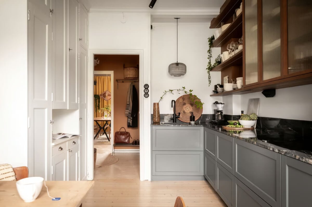 A Swedish Attic Apartment with Exposed Brick and Yellow Color Accents 10 kitchen with gray and wood cabinets