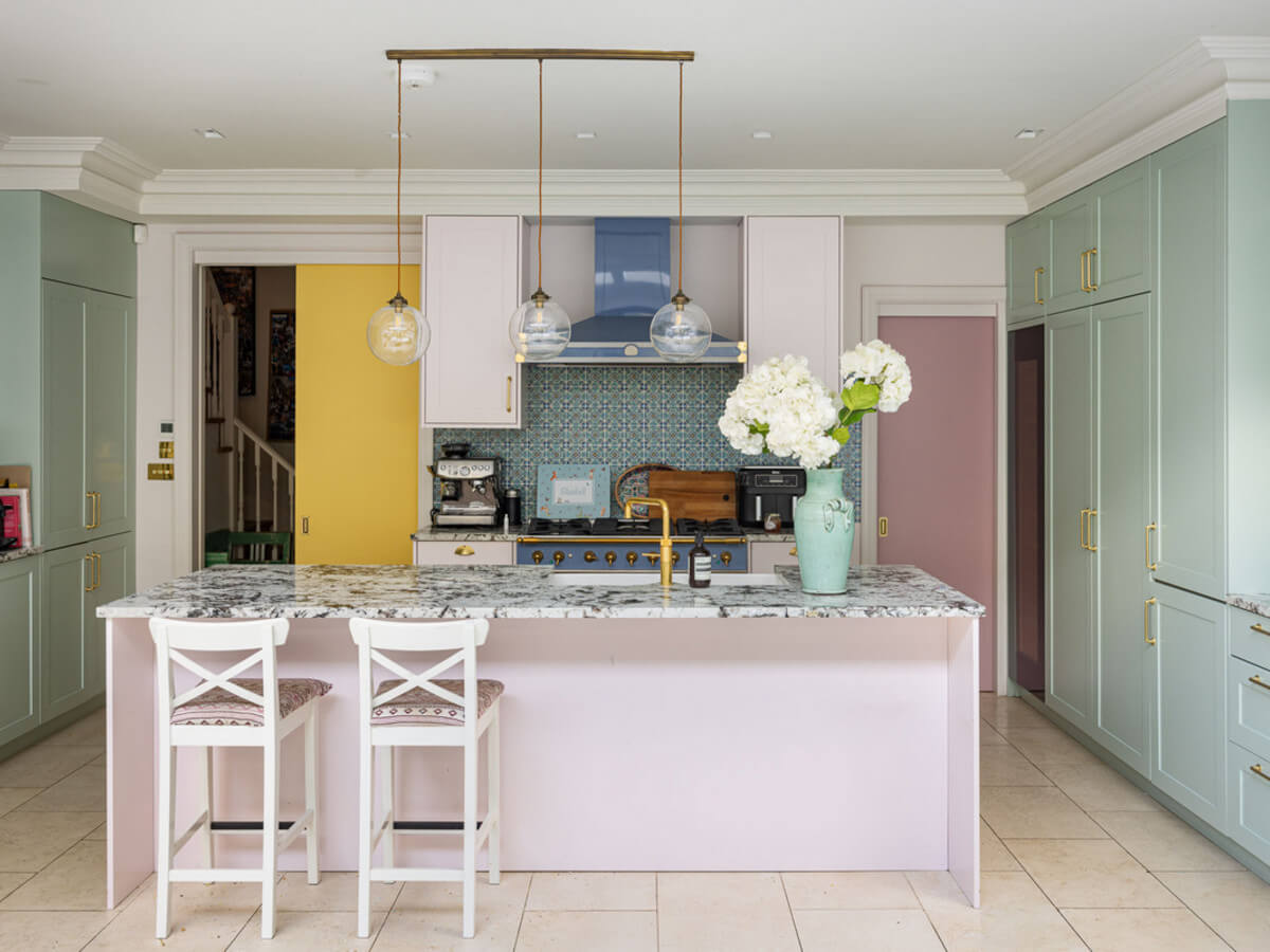 An Extended Family Home in London with Pink Crittall Doors 5 kitchen with island in pastel colors and marble worktop