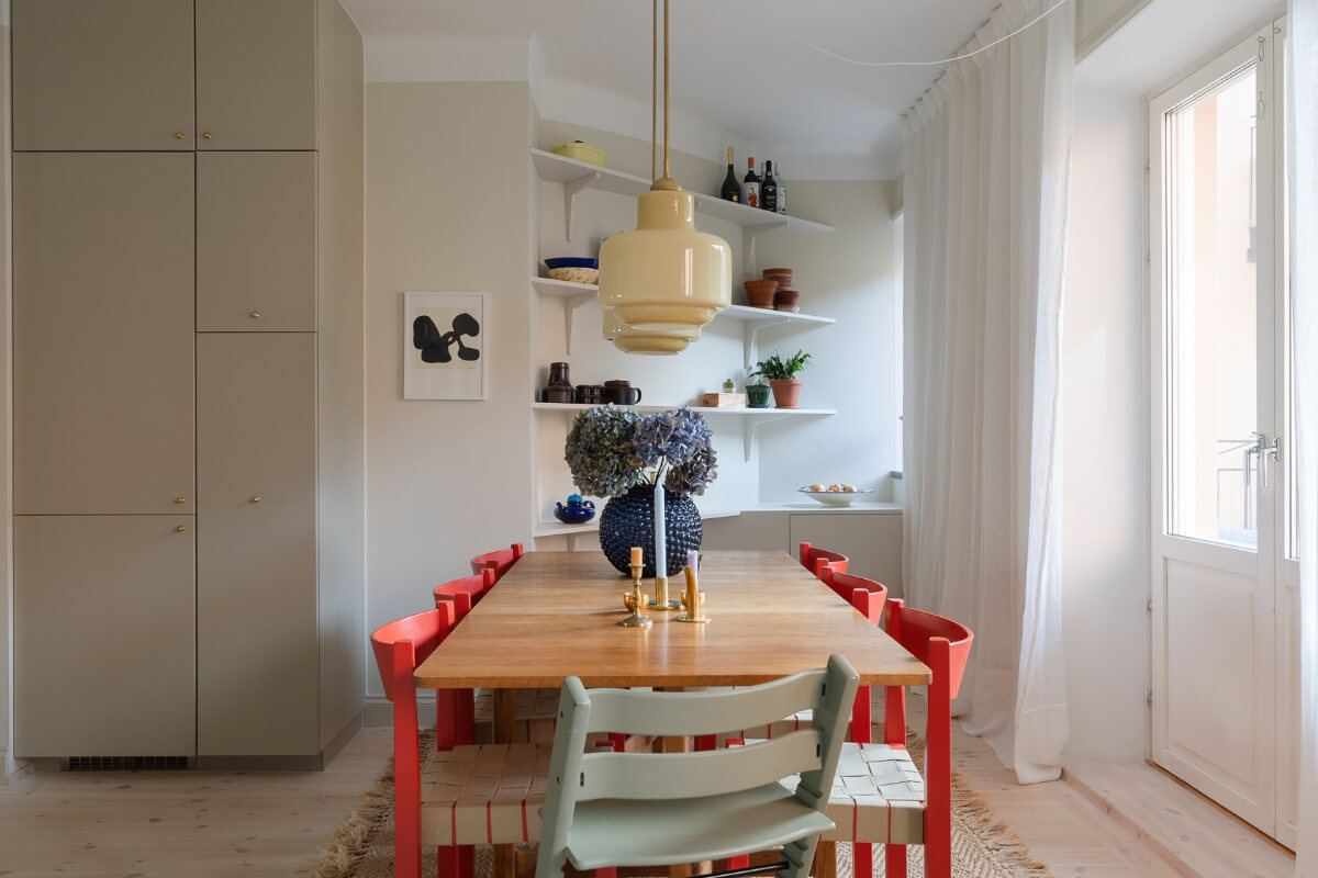 Modern Interiors in a Bright 1930s Apartment in Sweden 6 kitchen with large dining table colorful chairs