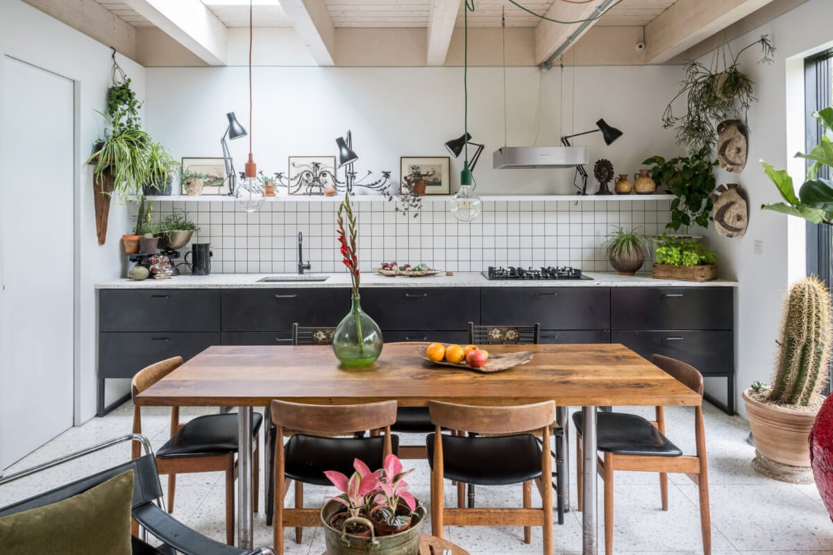 A Unique House in London with Plant-Filled Interiors and a Lush Garden 5 kitchen with wooden ceiling black cabinets and dining table
