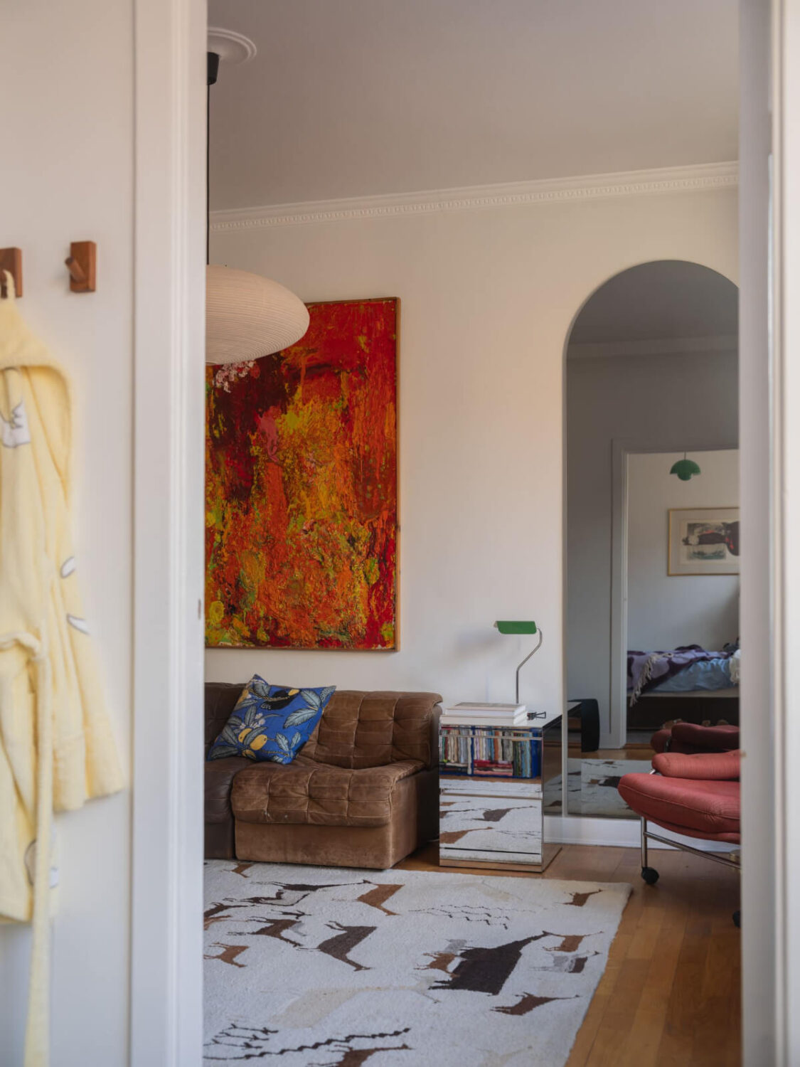 An Airy One-Bedroom Apartment with Art and A Yellow Kitchen 10 large arched mirror