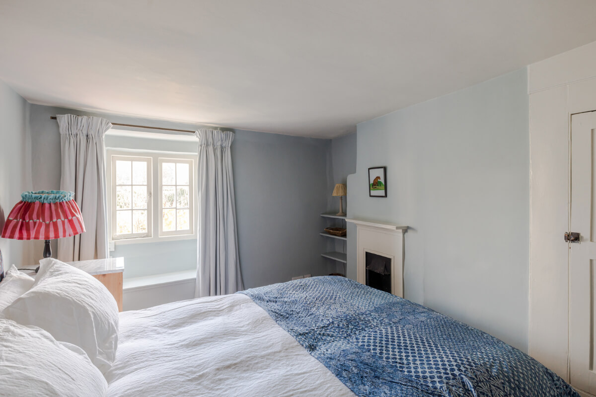 A Carefully Selected Color Palette in an 18th-Century English Cottage 10 light blue bedroom with fireplace