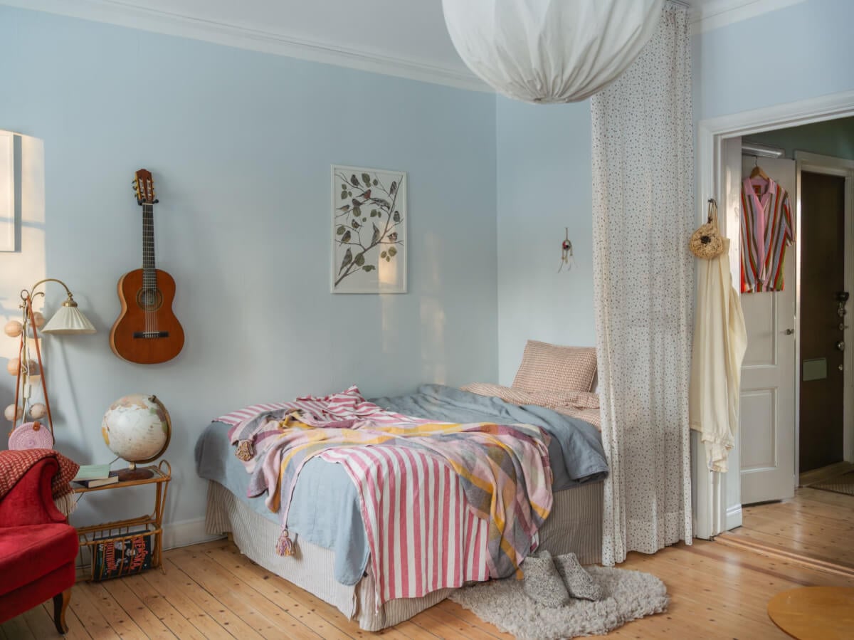 A Charming and Light-Filled Studio Apartment in Stockholm 6 light blue studio apartment curtain room divider