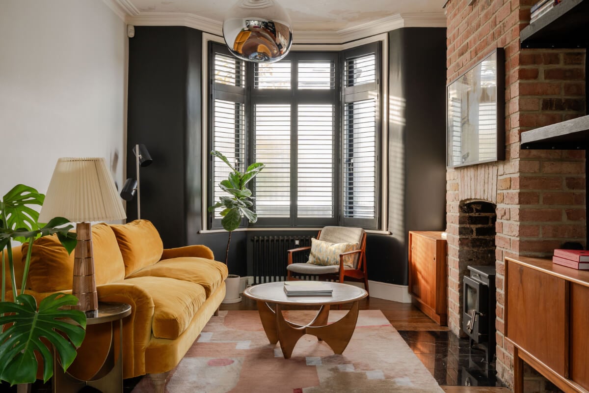 A Restored Victorian House with Exposed Brick and a Kitchen Extension 2 living room black bay window brick fireplace