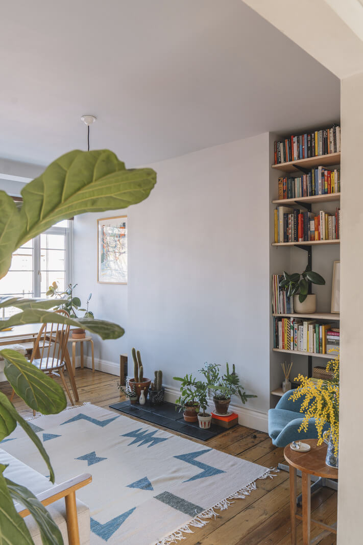 A London Apartment with a Pink and Green Kitchen 2 living room bookshelves wooden floorboards