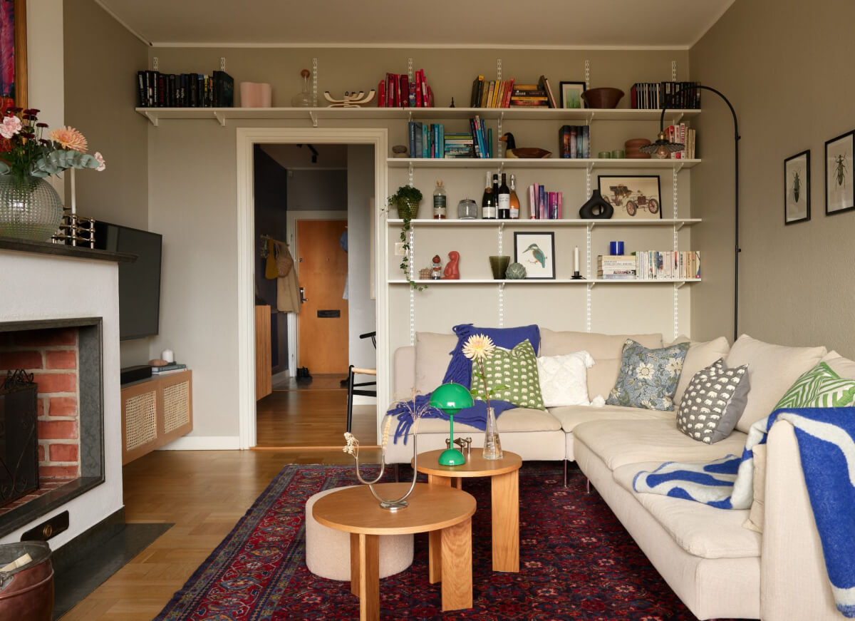 A Charming Two-Bedroom Corner Apartment in a 1940s Building 2 living room corner sofa bookshelves