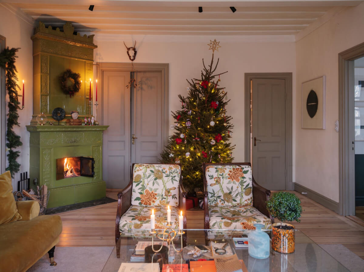 A Beautiful Turn-of-the-Century Family Home in Sweden 7 living room green fireplace floral armchairs