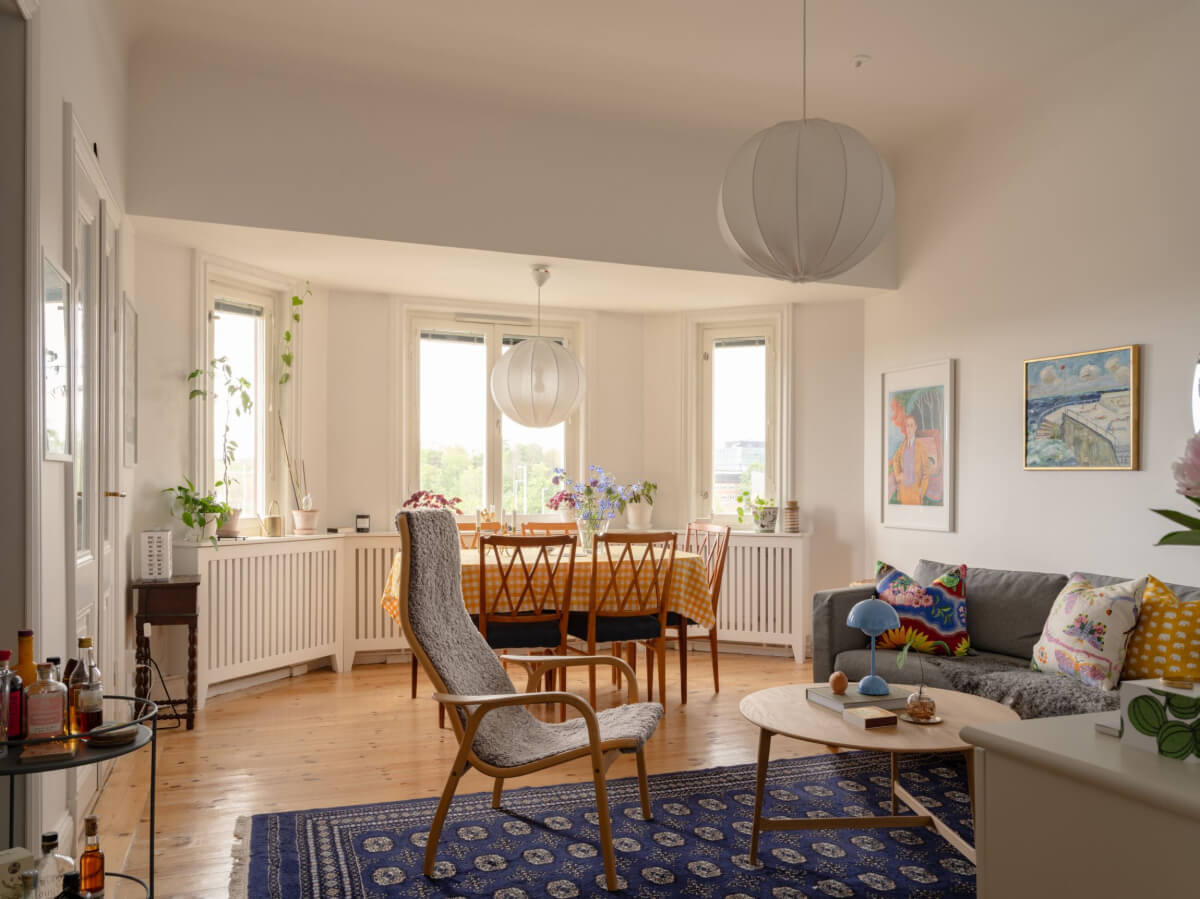 A Small Apartment with High Ceilings and a Large Bay Window 1 living room high ceiling bay window white walls