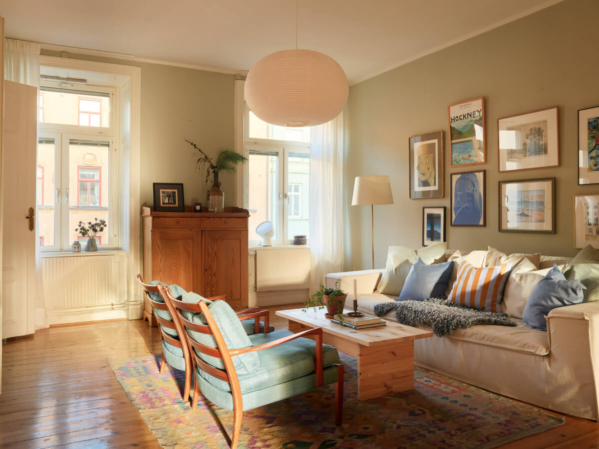 A Charming Historic Stockholm Apartment with a Blue Kitchen 15 living room large rug pastel colors