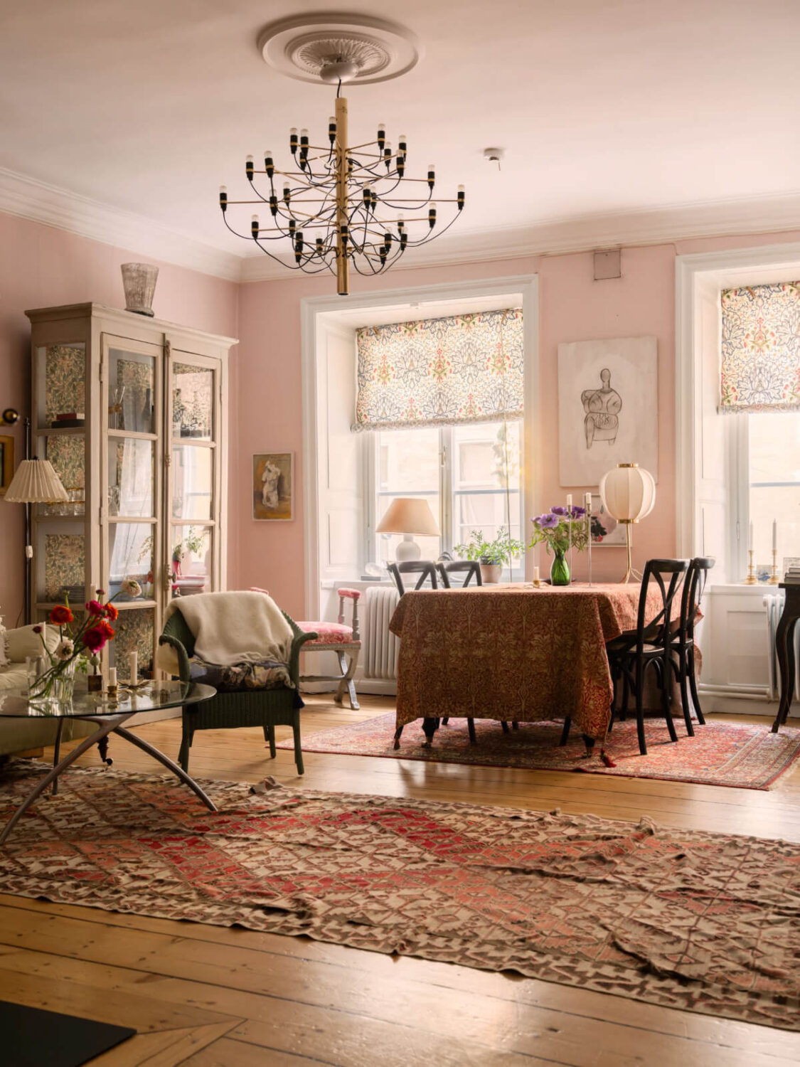 A Charming Home in a 17-Century Apartment in Stockholm's Old Town 4 living room light pink walls wide floorboards large rugs