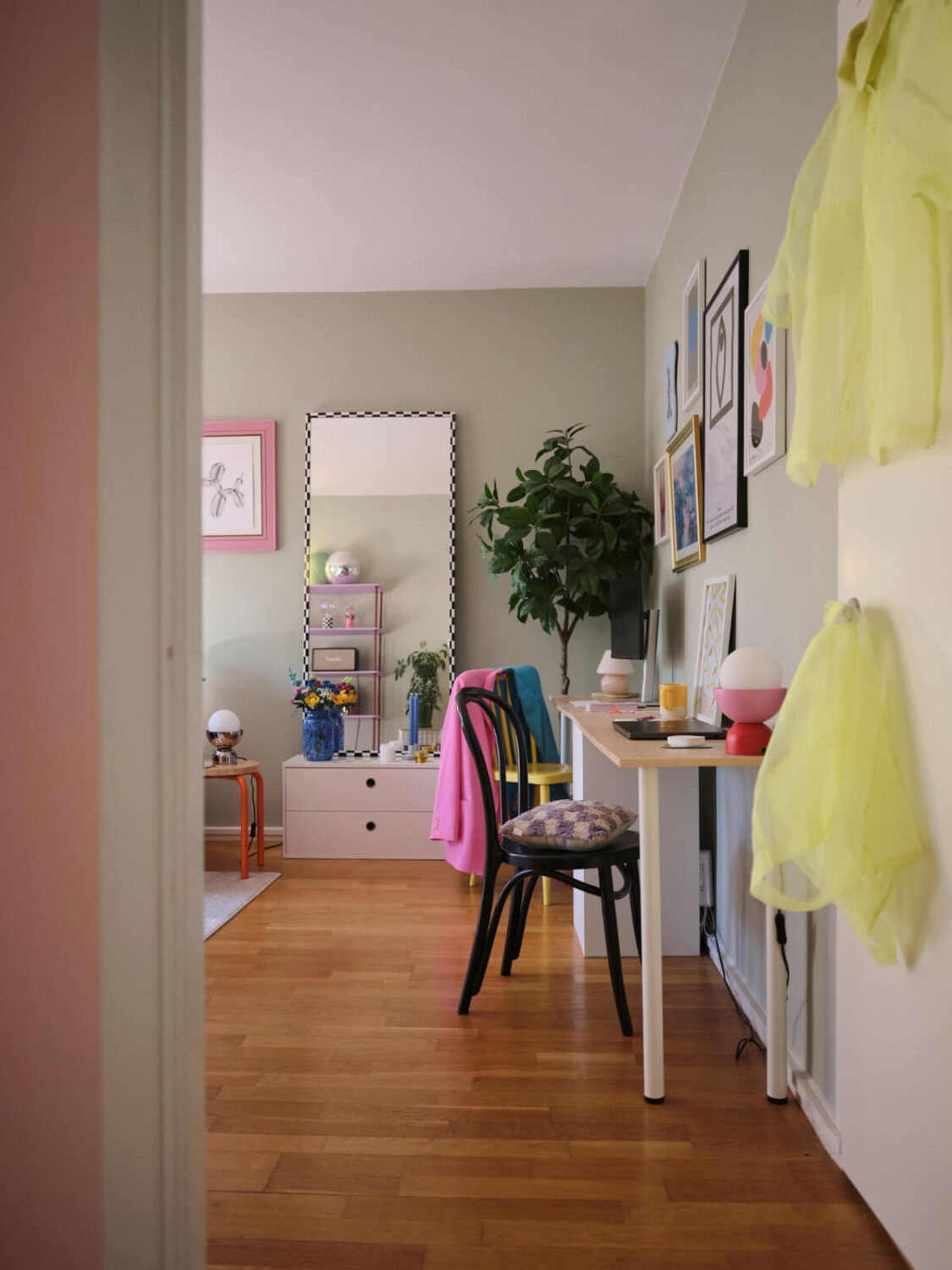 A Midcentury Swedish Apartment with Bright Color Accents 9 living room sage green walls and double desk