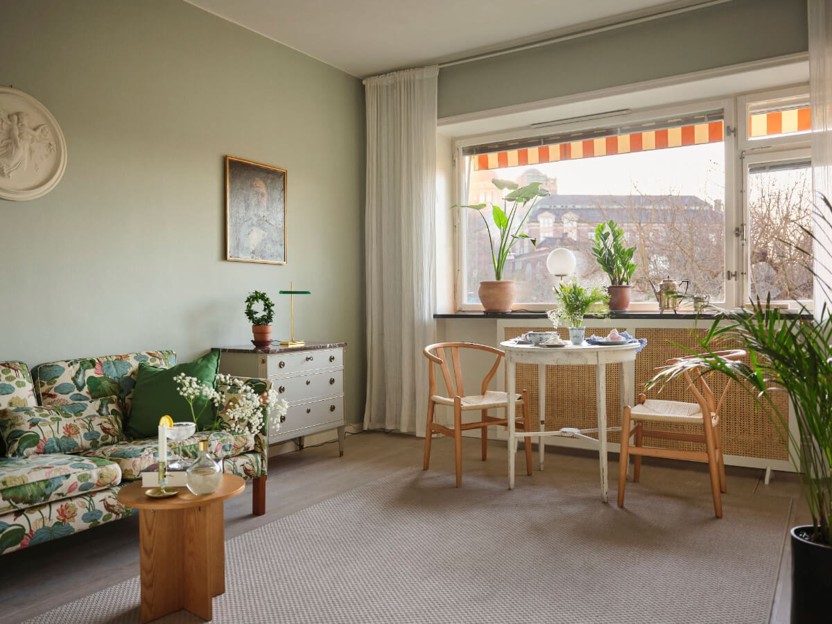 A Small Stockholm Apartment with a Tiny Green Bedroom 4 living room sage green walls patterned sofa