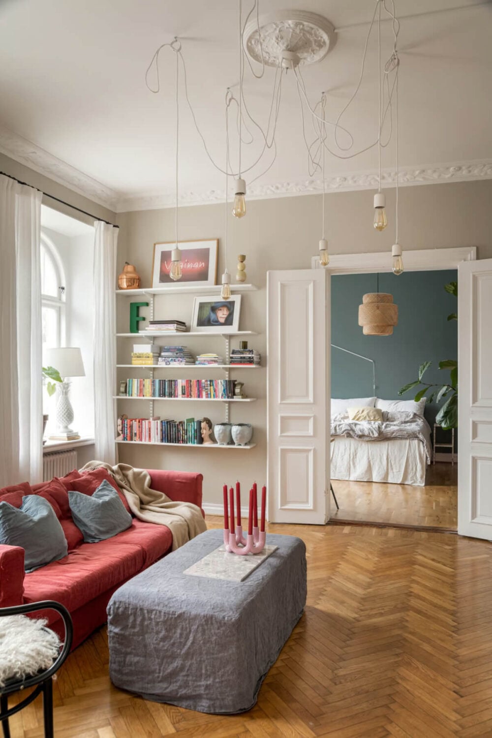 Large Rooms in an Art Nouveau Apartment in Sweden 1 living room with red sofa and parquet floor