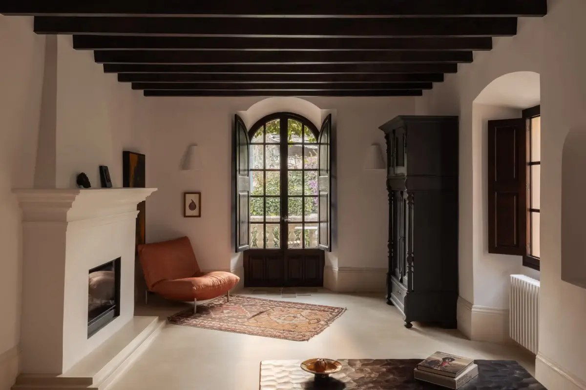 Old-World Craftsmanship and Contemporary Elegance in a Mallorcan Townhouse 6 living room with wooden ceiling beams fireplace shutters