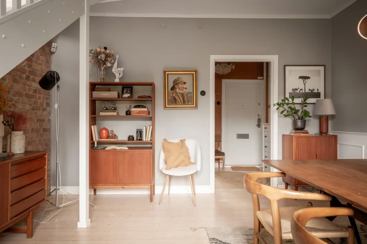 A Swedish Attic Apartment with Exposed Brick and Yellow Color Accents 5 midcentury furniture dining room with gray and brick walls