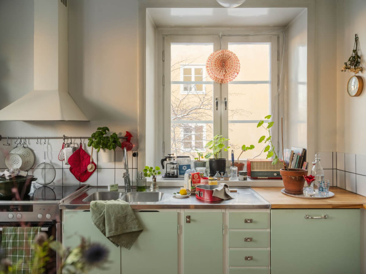 A Charming and Light-Filled Studio Apartment in Stockholm 9 midcentury kitchen green cabinets