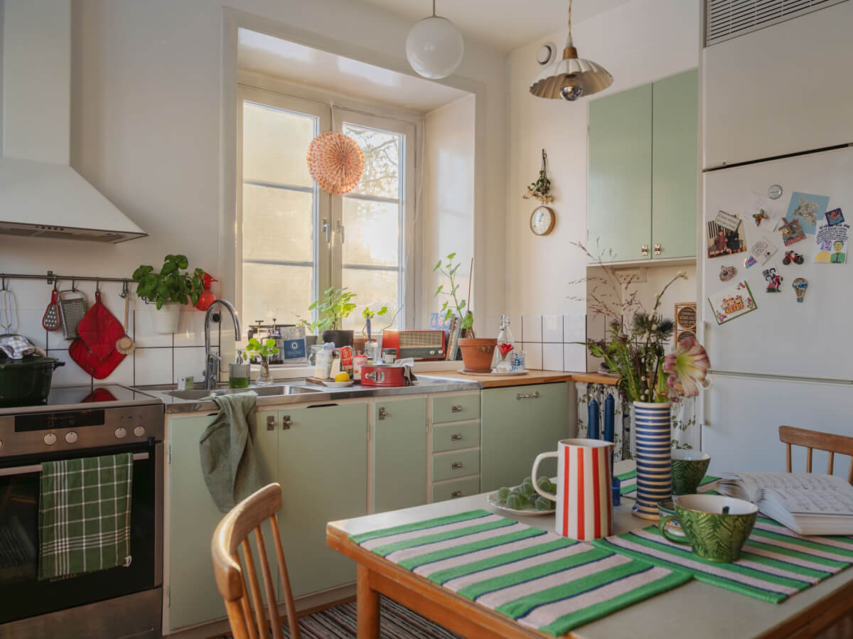 A Charming and Light-Filled Studio Apartment in Stockholm 10 midcentury kitchen with light green cupboards