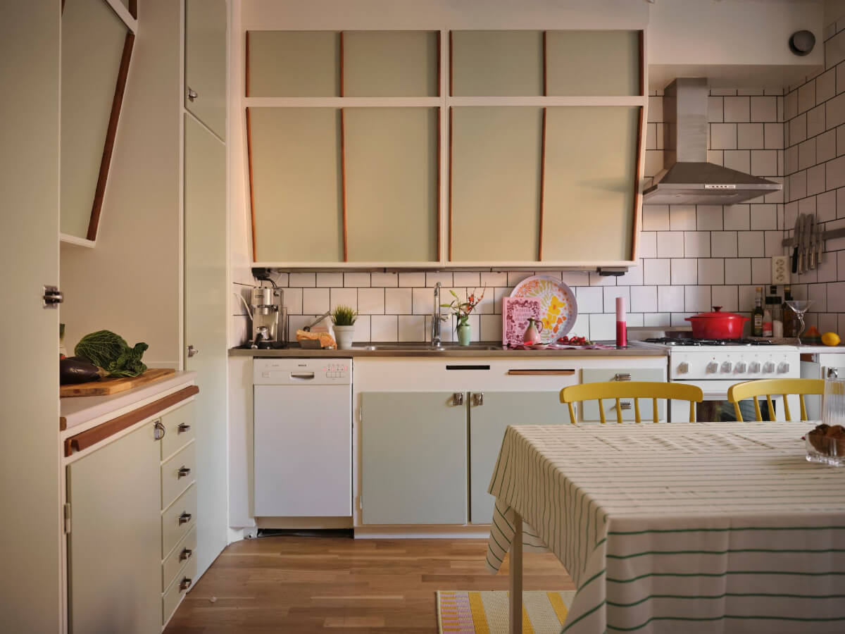 A Midcentury Swedish Apartment with Bright Color Accents 14 midcentury kitchen with sage green cabinet doors