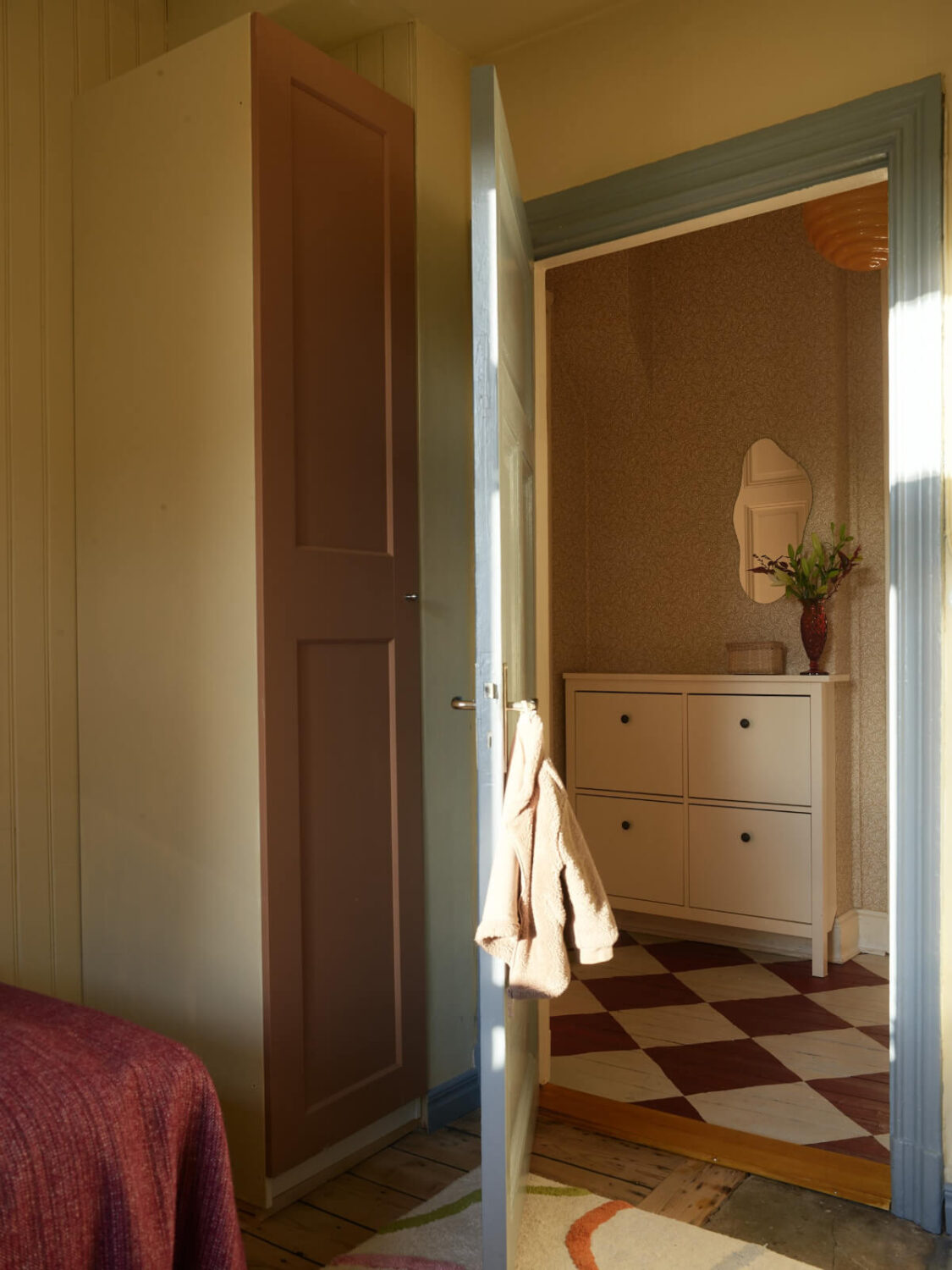 A Colored Sixth Wall May Be The Biggest Paint Trend in 2026 24 narrow wardrobe pink door view into hall with checkerboard floor