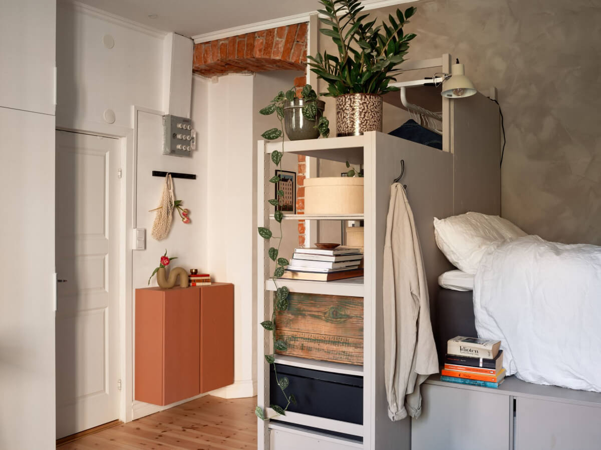 A Studio Apartment with Smart Storage Ideas and Exposed Brick 10 open cabinets room divider studio apartment