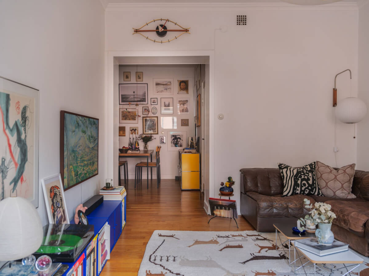 An Airy One-Bedroom Apartment with Art and A Yellow Kitchen 4 open plan living room dining space