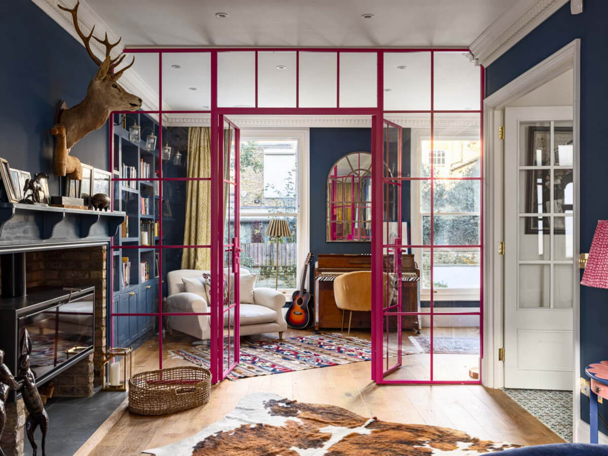 An Extended Family Home in London with Pink Crittall Doors 1 pink glass doors open living room dark blue walls