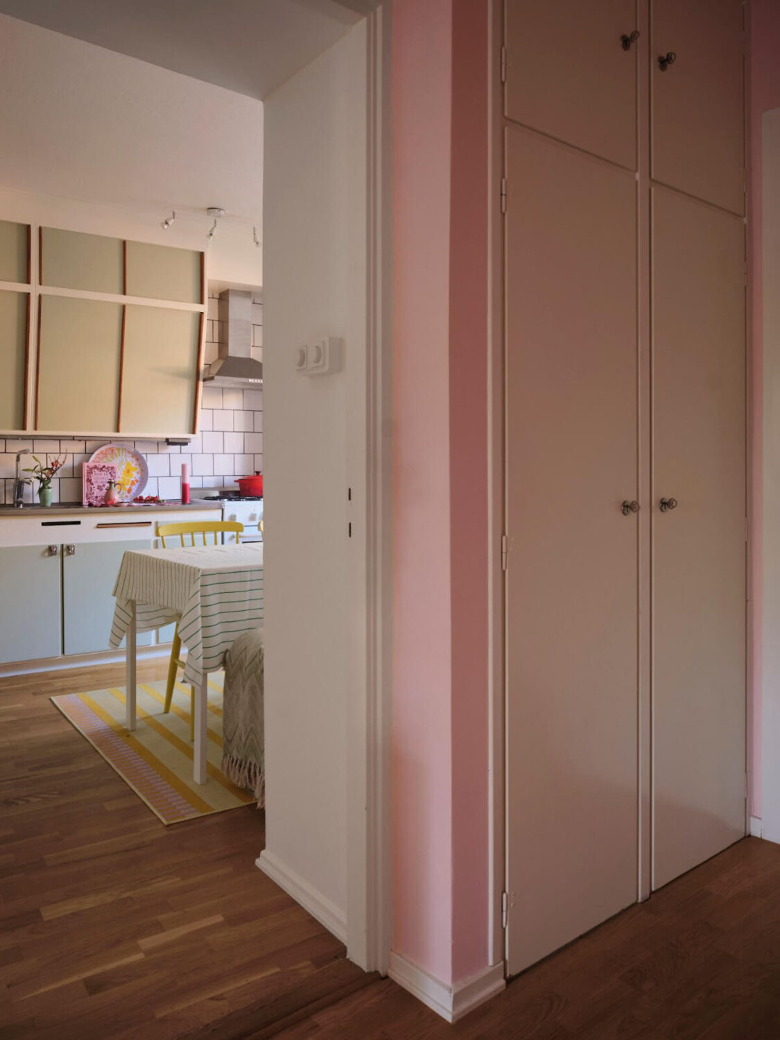 A Midcentury Swedish Apartment with Bright Color Accents 10 pink hall with original built in wardrobes
