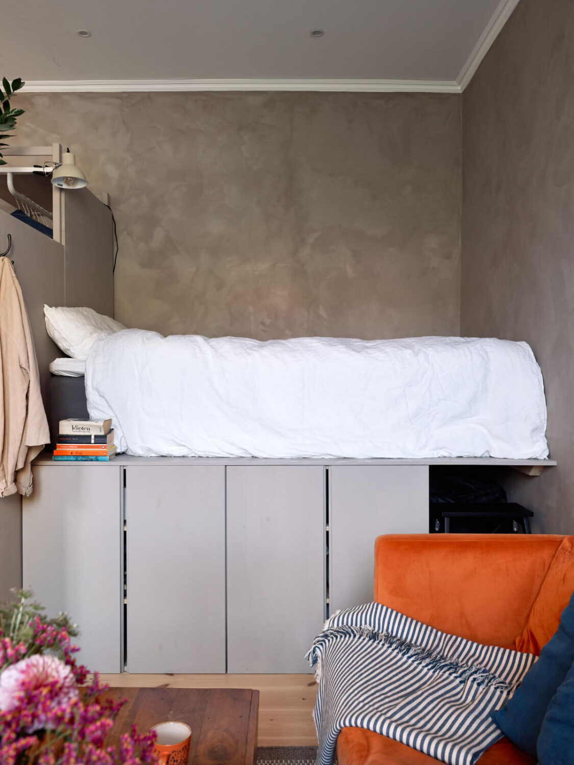 A Studio Apartment with Smart Storage Ideas and Exposed Brick 2 raised studio bed with underneath storage
