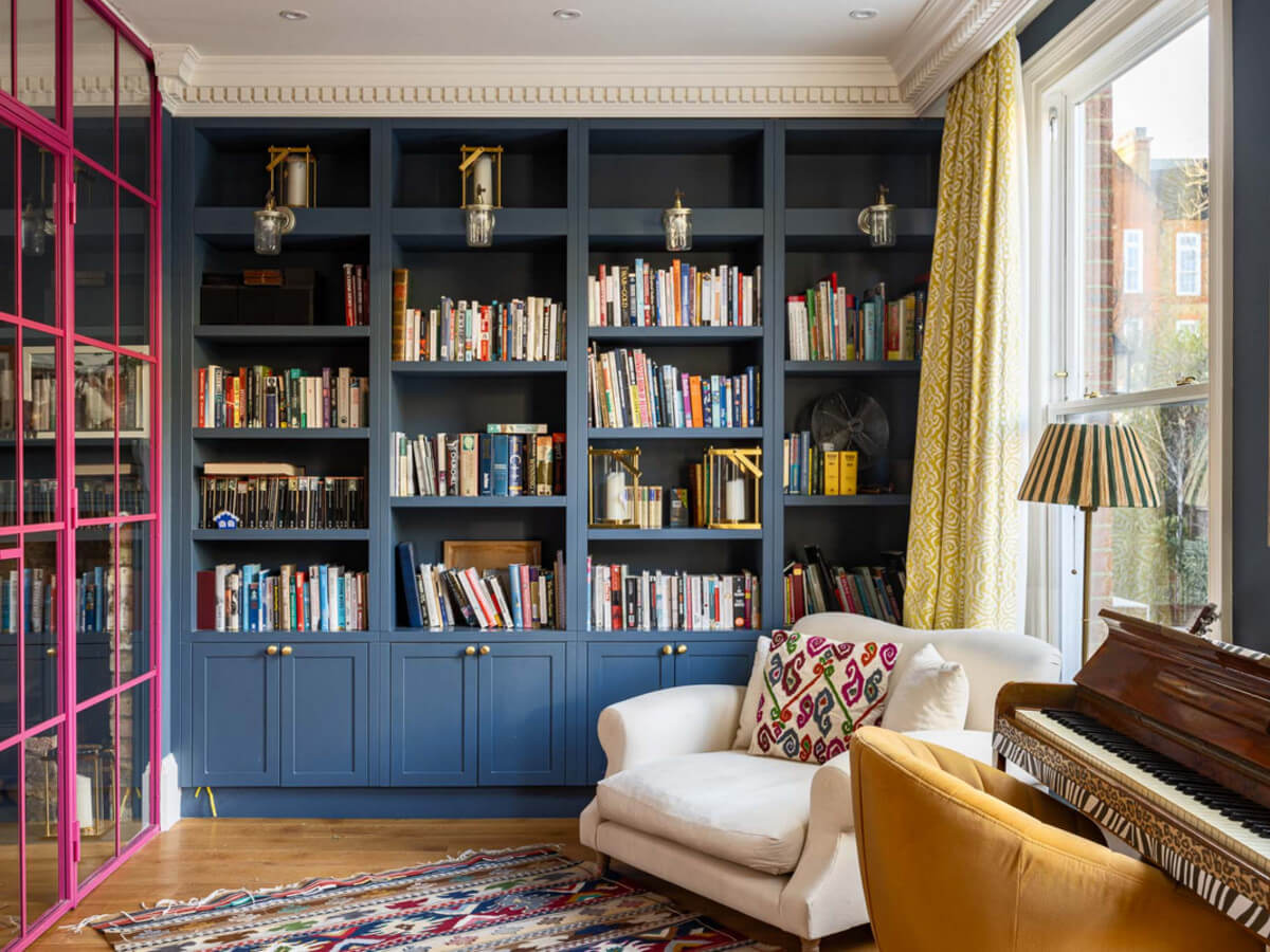 An Extended Family Home in London with Pink Crittall Doors 2 reading room with dark blue built-in bookcases