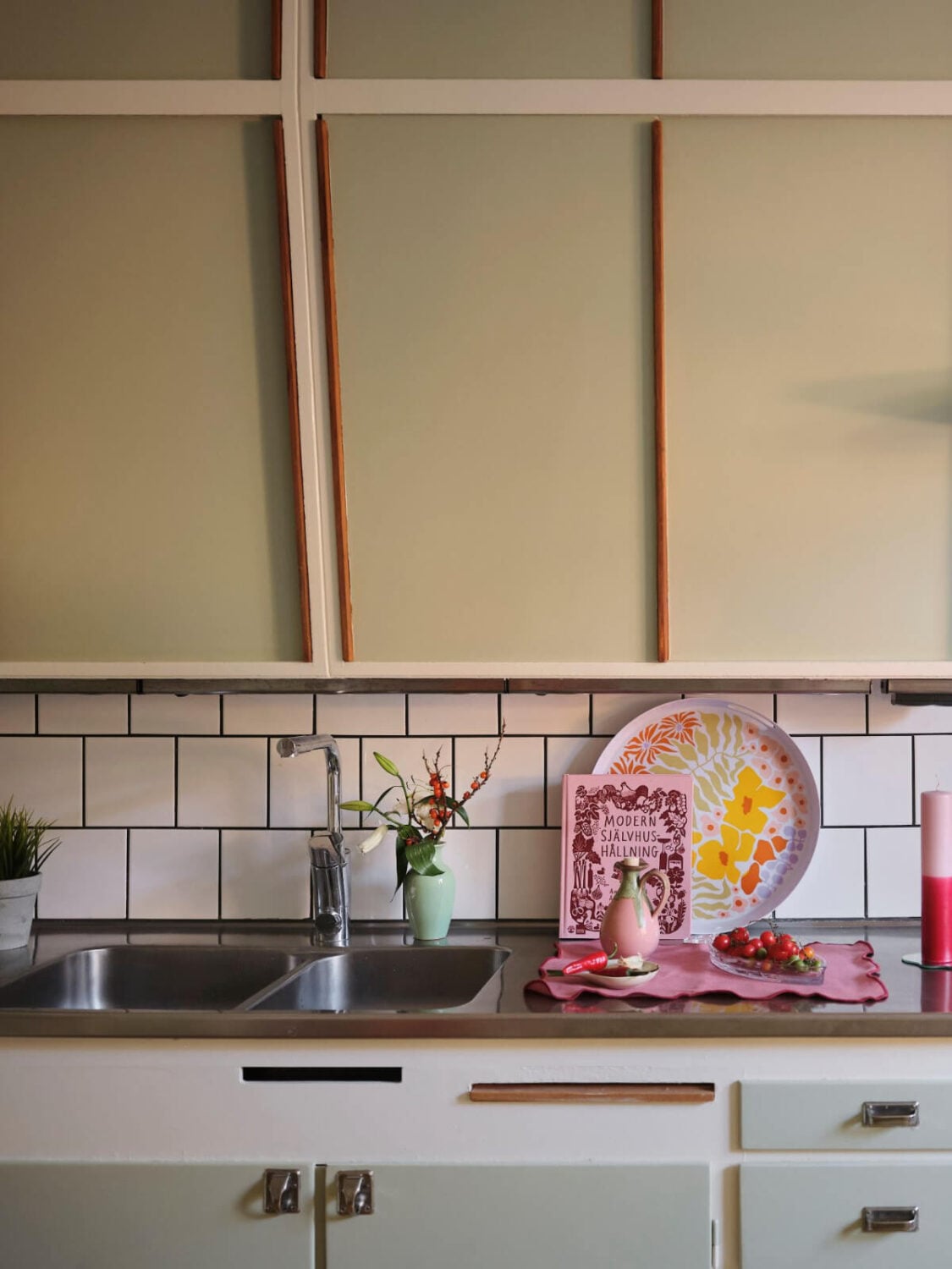A Midcentury Swedish Apartment with Bright Color Accents 12 sage green midcentury kitchen cabinets
