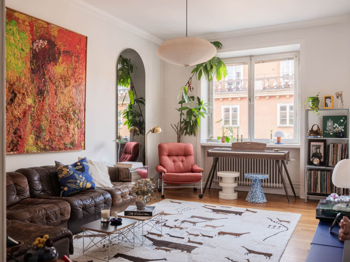 An Airy One-Bedroom Apartment with Art and A Yellow Kitchen 1 scandi living room brown leather sofa large arched mirror